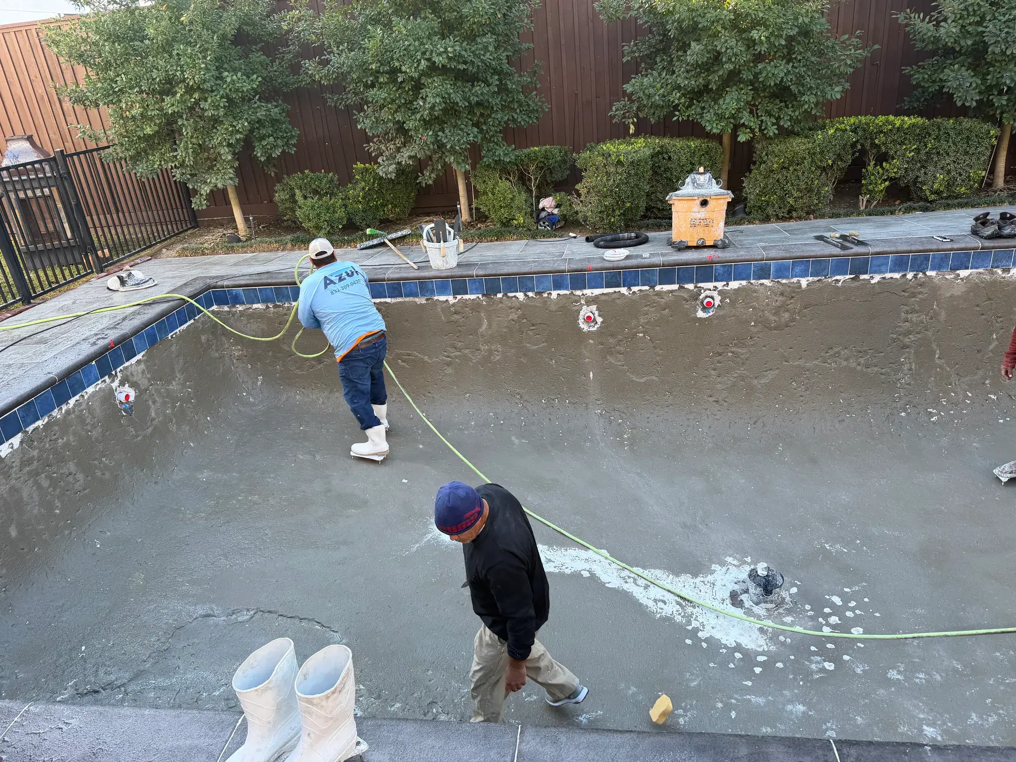 Crew prepping a drained pool for replastering during a Houston pool renovation