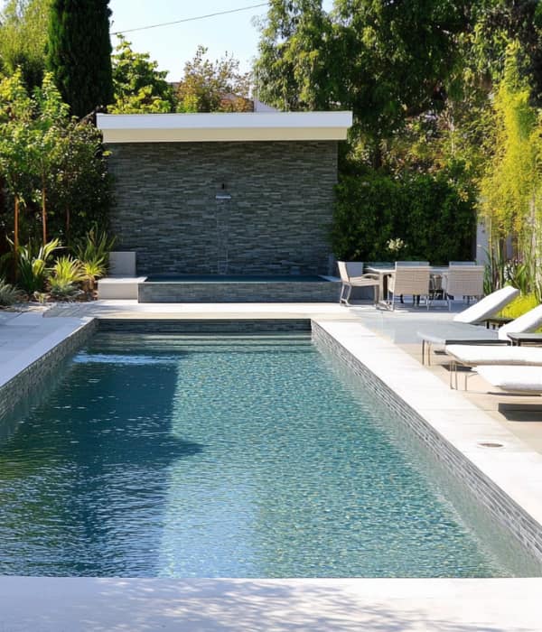 pool with stone wall and chaise loungers, Port Arthur TX pool services